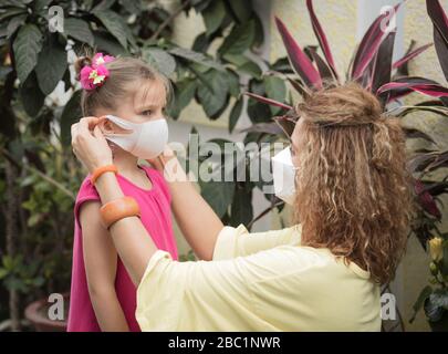 Frau und Tochter tragen eine Einwegmaske, um Virusinfektionen zu vermeiden. Schutz vor Coronavirus Stockfoto