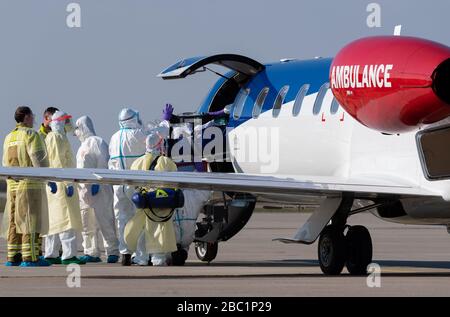 02. April 2020, Sachsen, Dresden: Ein schwer erkrankter Covid 19-Patient aus Frankreich wird aus einem Rettungsflugzeug am Internationalen Flughafen Dresden transportiert. Das Flugzeug Learjet 45 kam aus Metzger und landete am Nachmittag auf dem Flughafen Dresden. Wie das Universitätsklinikum Dresden auf Anfrage mitteilte, sollen am Abend zwei weitere französische Patienten eintreffen. Das Fachkrankenhaus Coswig, das Krankenhaus Dresden-Friedrichstadt und das örtliche Universitätsklinikum versorgen jeweils einen der Patienten. Über ihre Identität ist nichts bekannt geworden. Sachsen hatte davon bereits acht Patienten aufgenommen Stockfoto