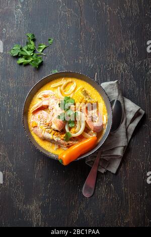 Peruanische Meeresfrüchtesuppe Chupe de Camarones in grauer Schüssel, Draufsicht. Stockfoto