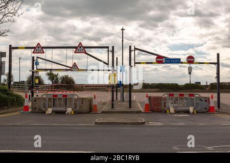 Southend-on-Sea, Großbritannien. April 2020. Betonbarrieren, Verkehrskegel und mehrere Straßenschilder behindern den Zugang zu einem Parkplatz oder einer Straße in Southend-on-Sea. Die Beschilderung enthält Zutrittsverbote und Gefahrenwarnungen, die auf eingeschränkten Zugang aufgrund von Sicherheit oder Wartung hinweisen. Palmen und bewölkter Himmel prägen die urbane Szene. Ein Parkplatz am Meer in Southend wurde mit Betonblöcken abgesperrt, um zu versuchen, die Menschen daran zu hindern, an die Küste zu fahren und soziale Zusammenkünfte während der Coronavirus-Pandemie zu treffen. Penelope Barritt/Alamy Live News Stockfoto