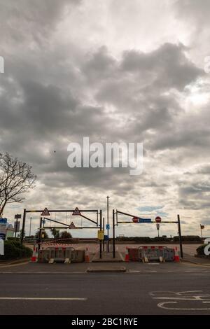 Southend-on-Sea, Großbritannien. April 2020. Betonbarrieren, Verkehrskegel und mehrere Straßenschilder behindern den Zugang zu einem Parkplatz oder einer Straße in Southend-on-Sea. Die Beschilderung enthält Zutrittsverbote und Gefahrenwarnungen, die auf eingeschränkten Zugang aufgrund von Sicherheit oder Wartung hinweisen. Palmen und bewölkter Himmel prägen die urbane Szene. Ein Parkplatz am Meer in Southend wurde mit Betonblöcken abgesperrt, um zu versuchen, die Menschen daran zu hindern, an die Küste zu fahren und soziale Zusammenkünfte während der Coronavirus-Pandemie zu treffen. Penelope Barritt/Alamy Live News Stockfoto