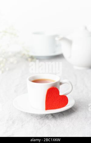 Valentinstag. Frühstück für zwei Personen mit Tee und Blumen. Rotes Filzherz ist Symbol der Liebenden Stockfoto