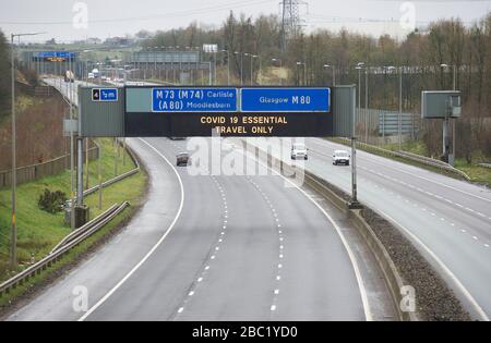 Coronavirus COVD 19, Glasgow. M80 Autobahn-Informationsschild mit Regierungsangaben zur wichtigen Verkehrsmeldung COVID 19. Stockfoto