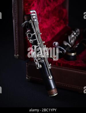 Vintage Bundy Wood Body Clarinet im Original Red Velvet-Lined Hartschalenstiel auf dunklem Hintergrund Stockfoto