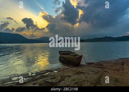 Ein einsames Boot am Ufer des Umiam-Sees bei Sonnenuntergang Stockfoto