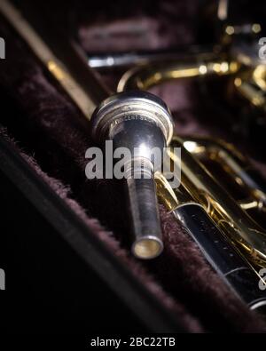 Yamaha YBL-421G Bass-Posaune mit F-Anhang in dunklem Velvet-Liniertem Hartschalen-Mundstück in Nahaufnahme auf dunkelschwarzem Hintergrund Stockfoto