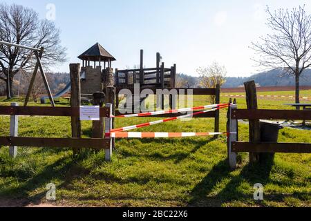 Der Spielplatz wurde mit einem Hinweisschild abgepfropft, das besagt, dass das Einsteigen aufgrund des Corona-Virus (COVID19) nicht zulässig ist. An einem sonnigen Frühlingstag in Potzbach parken. Stockfoto