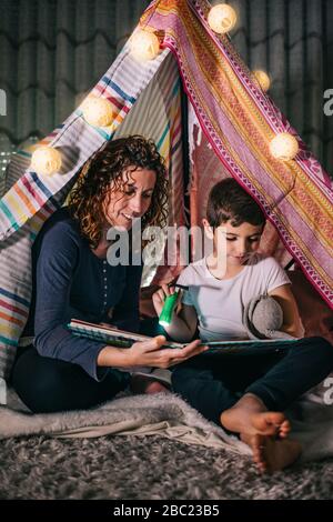 Mutter und Sohn lesen zu Hause ein Buch in einem Zelt Stockfoto