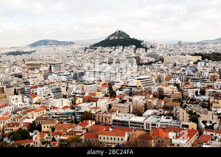 Der Berg Lycabettus erhebt sich über den Gebäuden im Zentrum Athens, Griechenland. Die Kapelle des heiligen Georg führt den Hügel hoch. Stockfoto