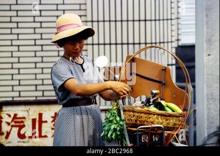 Hualien Taiwan-Frau legt einen Obstkorb auf ihren Roller Stockfoto