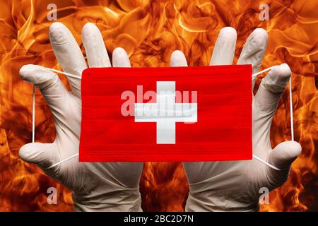 Arzt mit weißen Handschuhen Schutz medizinische Gesichtsmaske, Atemverband mit Landesflaggen Schweiz überlagert auf Maske. Konzept Stockfoto
