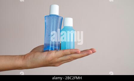In der Hand einer Frau befinden sich zwei Plastikflaschen mit Händedesinfektionsmittel. Coronavirus Konzept - Alkohol-Gel. Stockfoto