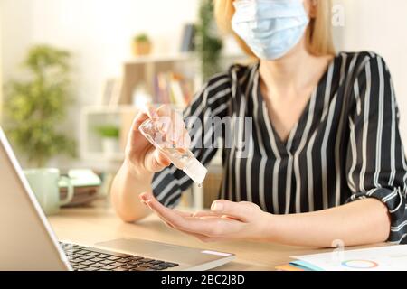 Nahaufnahme der Unternehmerin Hände mit Desinfektionsmittel reiben Vermeidung von Ansteckungsgefahr auf einem Schreibtisch im Heimbüro Stockfoto