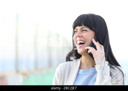 Fröhliche Erwachsene Frau lacht über das Smartphone draußen Stockfoto