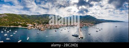 Luftpanorama über die Stadt Komiza - eine der zahlreichen Hafenstädte in Kroatien, ist eine Menge Segelboote einer Regatta, orangefarbene Dächer von Häusern, ein Stockfoto