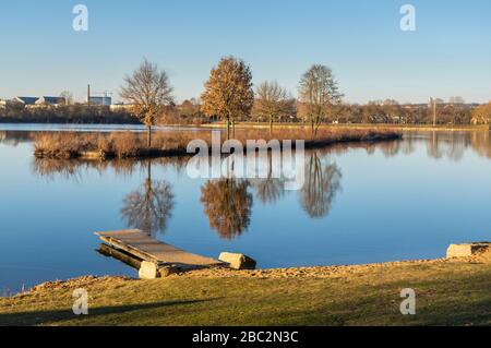 Idyllischer See mit Freizeiteinrichtungen und Erholungsgebiet im Frühjahr mit angrenzenden Kleingärten Stockfoto