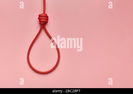 Hangmans Knoten, Kopierraum. Aufstachelung zum Suizid- oder Todesstrafe-Konzept. Rote geflochtene hängende Schlinge fesselte den Knoten. Stockfoto