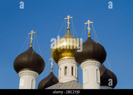 Goldene Kreuze und Kuppeln der russischen orthodoxen Kirche gegen den blauen Himmel. Stockfoto