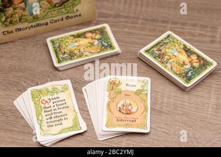 "Einmal pro Zeit", Geschichtenerspiel für bis zu sechs Spieler. Mehrere Kartendecks auf einem Holztisch. Wortruin im Fokus mit Endkarten Stockfoto