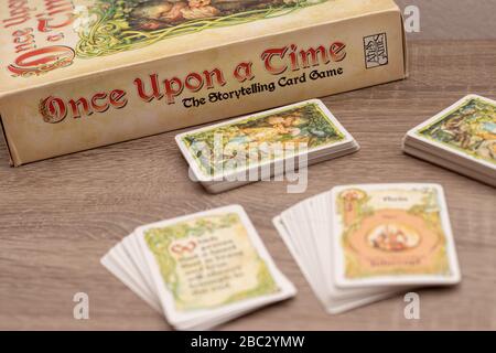 "Once Upon a Time", Geschichtenerspiel für bis zu sechs Spieler. Mehrere Kartendecks auf einem Holztisch außerhalb des Fokus, Spieltitel im Fokus, höher V Stockfoto