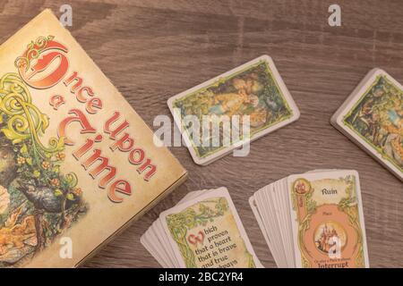 "Einmal pro Mal", Geschichtenerspiel. Flach lag auf Holztisch, Spieltitel links mit Karten auf dem Tisch Stockfoto