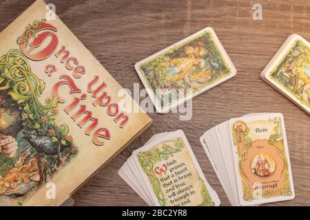 "Einmal pro Mal", Geschichtenerspiel. Flach lag auf Holztisch, Spieltitel links mit Karten auf dem Tisch Stockfoto