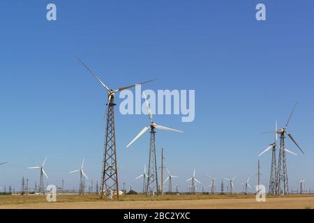 Riesige Klingen eines Windgenerators auf einem hohen Mast in der Krimsteppe . Eine unerschöpfliche Energiequelle Stockfoto