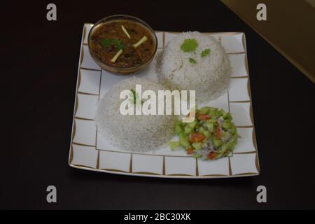 Zwei Schalen Reis mit gekochten roten Bohnen und Salat kochen Stockfoto