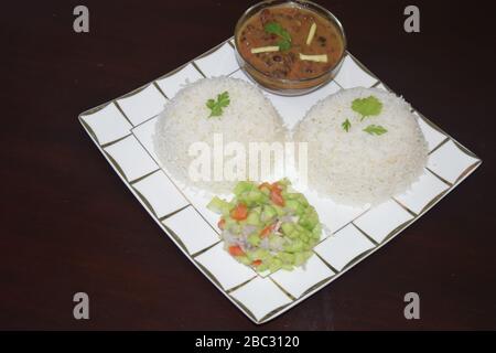 Zwei Schalen Reis mit gekochten roten Bohnen und Salat kochen Stockfoto