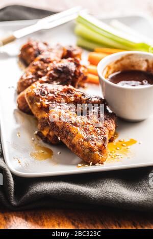 Gegrillte Hühnerflügel mit BBQ-Sauce auf dem Teller. Stockfoto