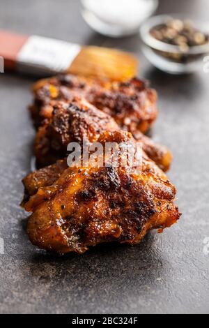 Gegrillte Hühnerflügel auf schwarzem rustikalen Tisch. Stockfoto