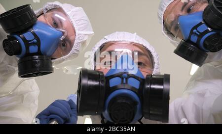 Notarztdienst. Ärzte in Schutzanzügen tragen den Patienten. Stockfoto