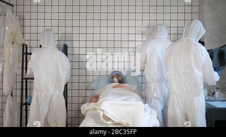 Ärzte in Hazmat steriler Anzug um den Patienten in einem Krankenhaus. Stockfoto