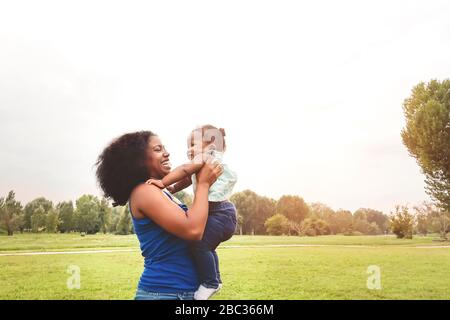 Glückliche Mutter hat Spaß mit ihrer Tochter im Park im Freien - liebevolle Familie genießt gemeinsame Zeit - Eltern lieben und Mutter Tageskonzept Stockfoto