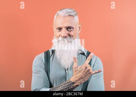 Ein erfahrener Mann, der Spaß hat, sich vor der Kamera zu posieren - ein glücklicher, reifer Mann genießt im Ruhestand - ein Lifestyle- und ein Konzept für die Hipper-Kultur für ältere Menschen Stockfoto