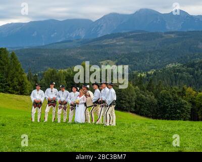 Hohe Tatra-Berge in Polen. Blick von Lapszanka in der Nähe von Zakopane. Leute in traditionellem Outfit, die Hochzeit im Shooting an einem fantastischen Ort haben. Stockfoto