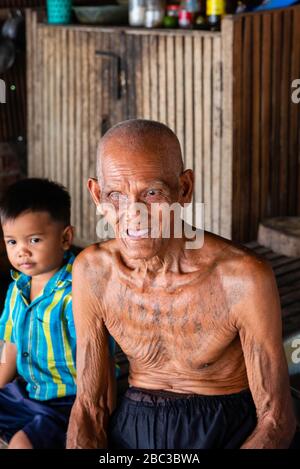 Ein Khmer/kambodianischer Veteran des Südostasienkrieges zeigt seine Tätowierungen in seinem Haus. Stockfoto