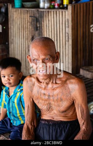 Ein Khmer/kambodianischer Veteran des Südostasienkrieges zeigt seine Tätowierungen in seinem Haus. Stockfoto