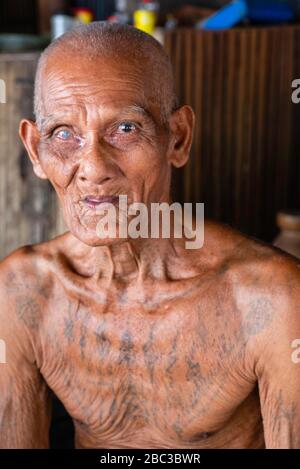 Ein Khmer/kambodianischer Veteran des Südostasienkrieges zeigt seine Tätowierungen in seinem Haus. Stockfoto