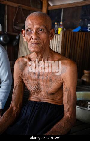 Ein Khmer/kambodianischer Veteran des Südostasienkrieges zeigt seine Tätowierungen in seinem Haus. Stockfoto