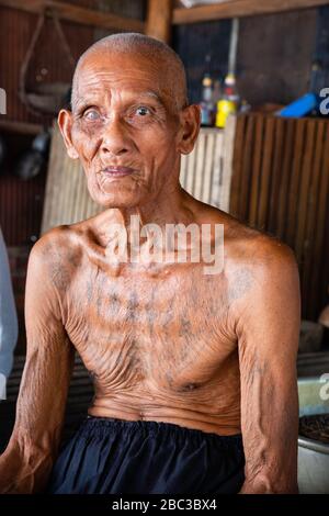 Ein Khmer/kambodianischer Veteran des Südostasienkrieges zeigt seine Tätowierungen in seinem Haus. Stockfoto