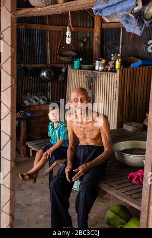 Ein Khmer/kambodianischer Veteran des Südostasienkrieges zeigt seine Tätowierungen in seinem Haus. Stockfoto