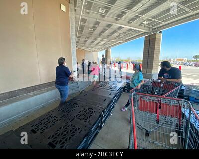 Käufer sind bei Costco dabei, soziale Distanzierung aufrechtzuerhalten. Holzpaletten wurden aufgestellt, um Menschen dabei zu helfen, sich auseinander zu halten und eine Linie zu bilden, die genügend Raum zueinander hat. Stockfoto