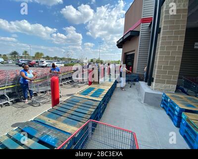 Käufer sind bei Costco dabei, soziale Distanzierung aufrechtzuerhalten. Holzpaletten wurden aufgestellt, um Menschen dabei zu helfen, sich auseinander zu halten und eine Linie zu bilden, die genügend Raum zueinander hat. Stockfoto