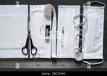 Antivirenschutz. Nähte Schutzmasken mit eigenen Händen aus schwarzem Stoff. Details und fertige Maske Stockfoto