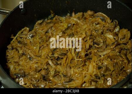 Gebratener Kohl mit Champignons in einer Pfanne Stockfoto