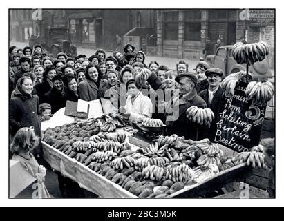 Vintage-Archiv 1940s Food Rationing Market Stall 1946 Post war WW2 Frische Bananen und Rote Beete werden in East End London verkauft, mit einer Menge sehr eifriger Kunden rund um den Stall Bethnal Green London UK Stockfoto