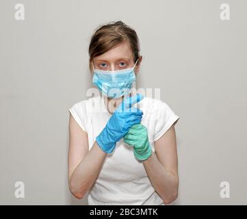 Junge medizinische Fachkraft mit Gesichtsmaske, Handschuhe mit Reagenzglas im Labor Stockfoto