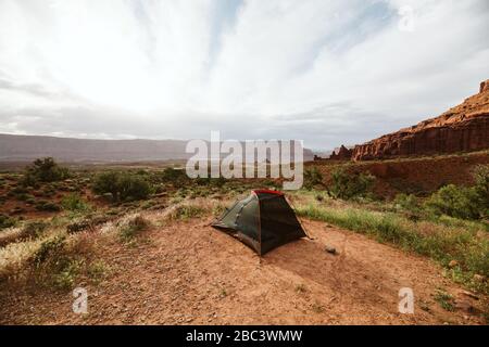 Schwarzes Zelt bei moab utah unter roten Sandsteinbügeln Stockfoto