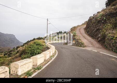 Leere kurvenreiche Bergstraße an einem bewölkten Tag Stockfoto